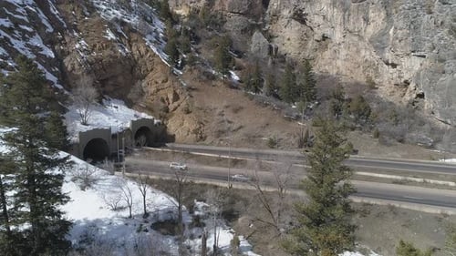 Highway vehicles enter tunnels in snowy Glenwood Canyon, Colorado