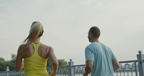 Athletic Couple Running Together in City