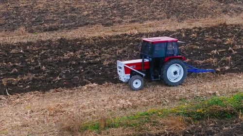 Farm Tractor Plowing Field
