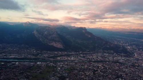 Aerial panoramic footage of Grenoble city between the river and high alps mountain during amazing cl