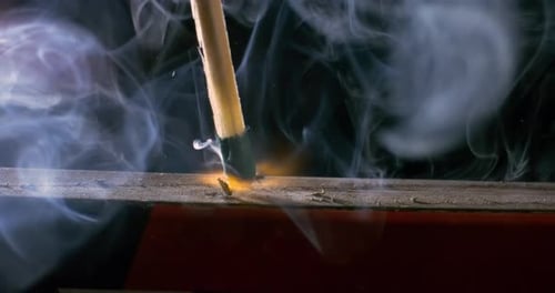 Burning matchstick close-up on a dark background. Shot on super slow motion camera 1000 fps.
