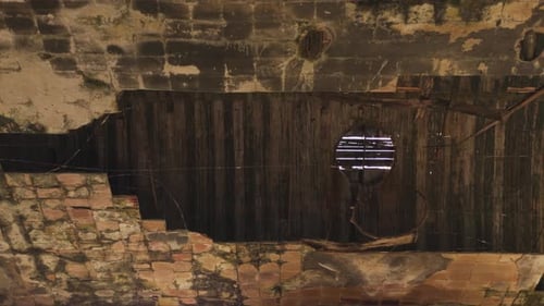 Cinematic aerial drone footage gliding through an abandoned factory interior. Slow and atmospheric