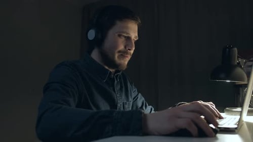 Man Working on Laptop During Video Call at Night