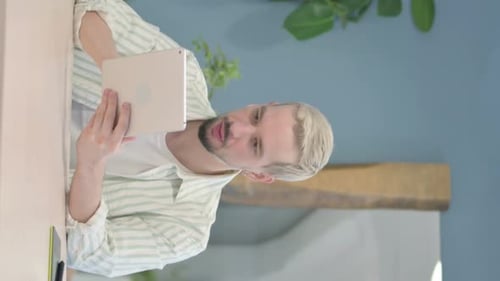 Young Adult Chatting on Tablet Indoors