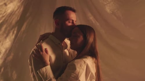 Zeitlupe eines sich umarmenden Paares im Studio, das Licht im Hintergrund ausschaltet, junger Freund, sinnlich