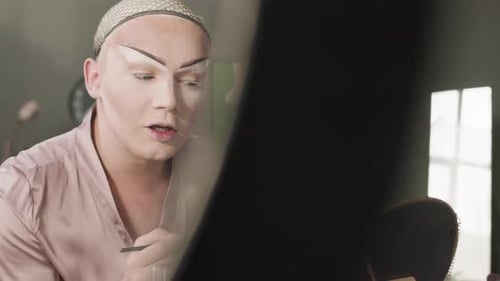 Queer Man with Graphic Brows Doing Makeup at Home