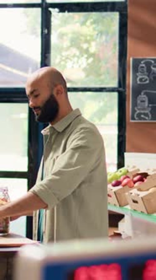 Vídeo vertical: Hombre llenando una bolsa de papel con pasta
