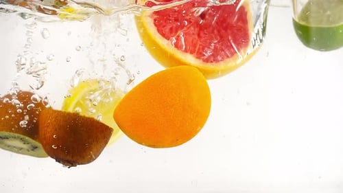 Halved Fruit Plunging Into Clear Water