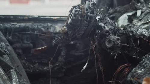 View inside charred and melted car destroyed by fire, pan