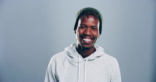 4k video footage of a young man laughing against a grey studio background