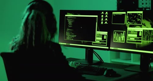 Woman Working on Computers in Dark Green Office