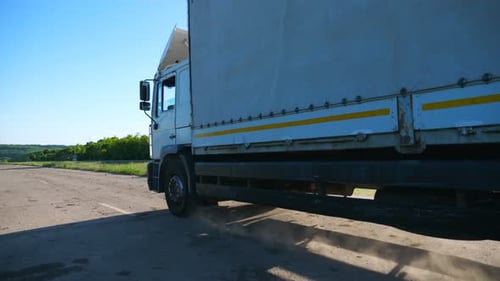 Side View of Truck with Cargo Trailer Driving Along Empty Freeway and Transporting Goods Lorry