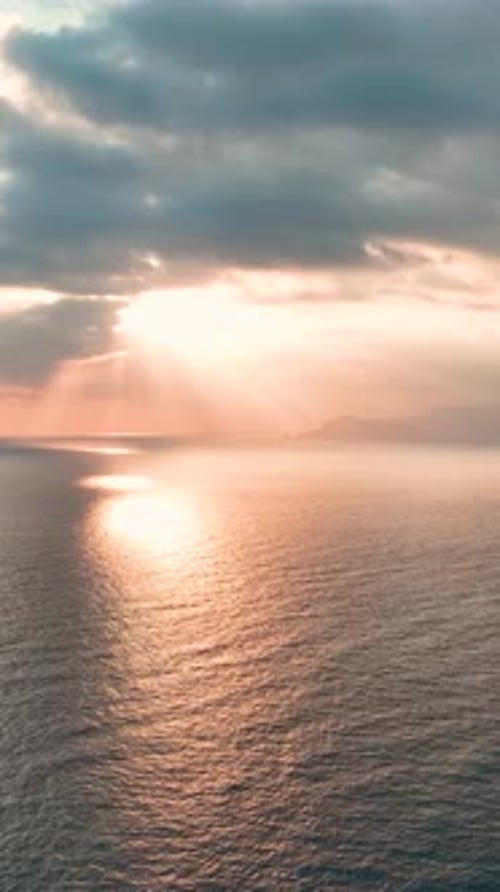Vidéo verticale Des nuages dorés mettent en valeur un coucher de soleil ardent sur la mer Méditerranée, créant ainsi un spectacle époustouflant