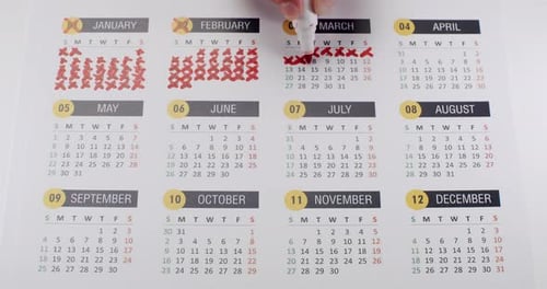 Marking Dates on Annual Calendar with Red Pen