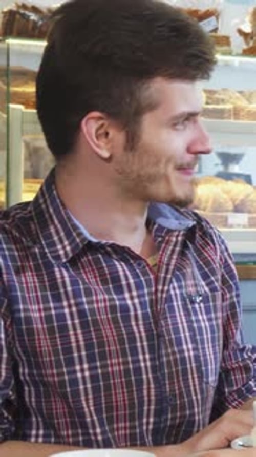 Young People Enjoying Lively Conversation Over Coffee at a Cozy Cafe