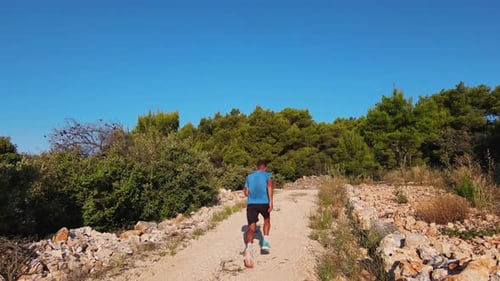 Mann joggt auf einem felsigen Pfad in der Natur
