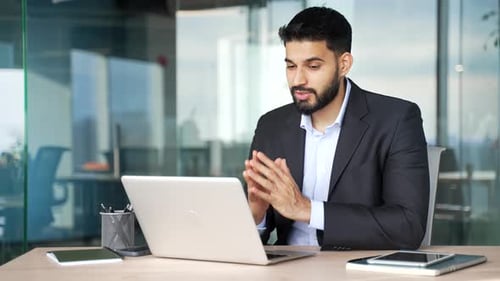 Businessman in formal suit talking on a video call conference using laptop sitting