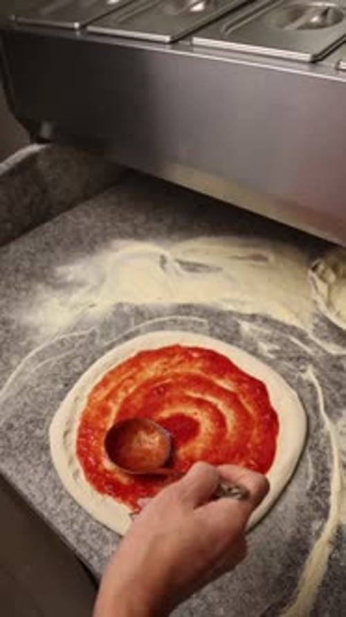 The chef makes delicious pizza in a professional kitchen.