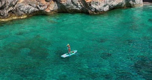 Woman Stand-up Paddle Boarding On The Beach Of Gjipe In Albania. Aerial Shot