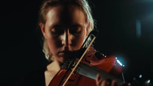 Woman Playing Violin in Dark Setting Close Up