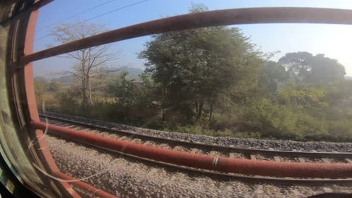 Train window leaning out point of view during long distance train ride travel, Indian Railways