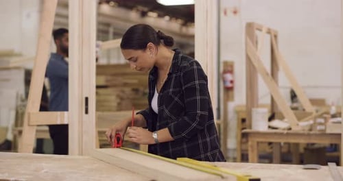 4k video footage of a woman in a wood workshop marking out measurements on a piece of wood