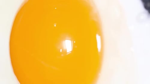 Ein Ei in einer Pfanne kochen, Spiegelei kochen (Vertikales Video)