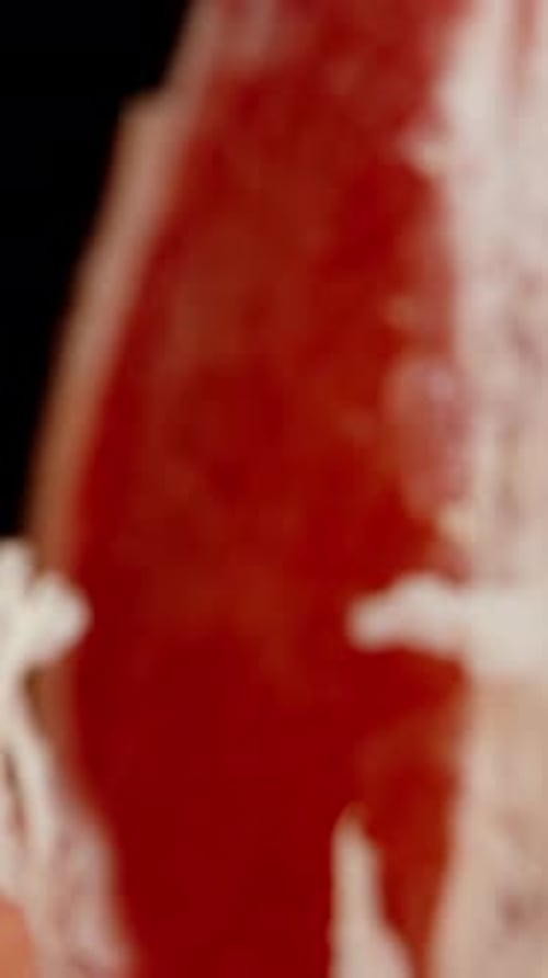 Vertical video. Inside a torn grapefruit, red flesh in macro. Dolly slider.