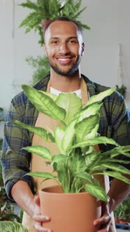 Portrait of Goodlooking Contented Botanical Gardener Worker in Uniform Standing in Flower Store and
