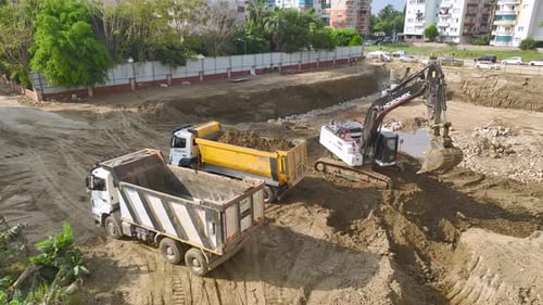 Hubwagen und Bagger arbeiten auf dem Baustellenfundament