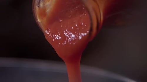 Close Up Shot Of Red Tomato Sauce Poured Out Of Glass Bottle