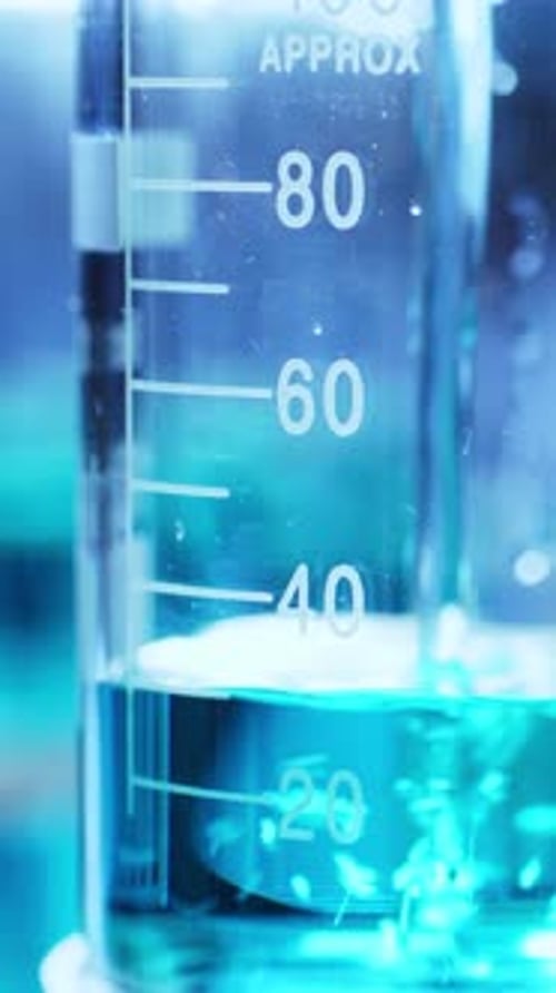 Blue Chemical Solution Filling Up Glass Beaker in Laboratory