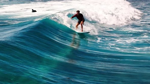 Man Surfs the Wave Aerial View of the Male Surfer Riding the Wave in the Maldives