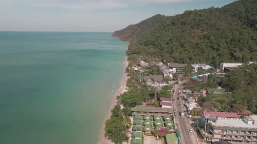 Aerial view of road and the beach hotels-resorts stretching in the coastal beach of an ocean.