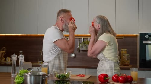 Pareja mayor cocinando ensalada con verduras frescas y saludables en la cocina Mujer y hombre maduros divertidos