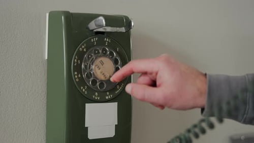 Closeup of a Man Finger Dialing a Number on Vintage Rotary Telephone The Scene Represents Classic