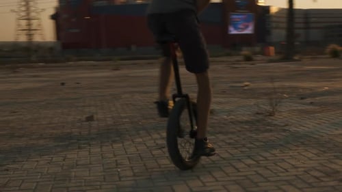 Man Rides a Unicycle at Sunrise