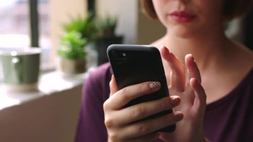 Woman Uses Smartphone Indoors During Daytime