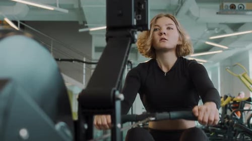 Woman Using Rowing Machine at Gym