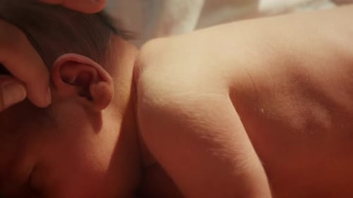 Close-up of a newborn baby resting. Ideal for parenting or healthcare productions. Gently getting to