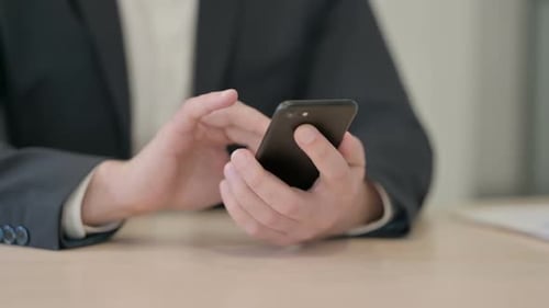 Close up of Businessman Browsing Internet on Smartphone