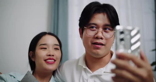 Cheerful Young Couple Video Calling at Home