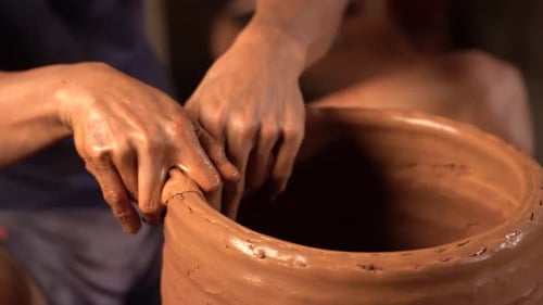 Close Up of Hands Shaping Clay on Pottery Wheel