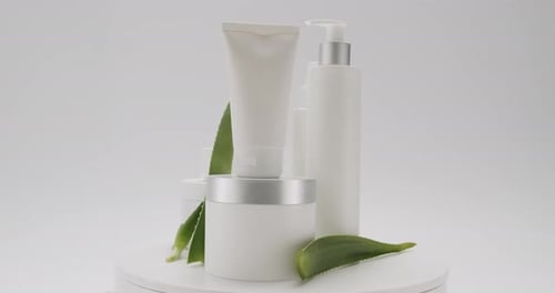 Cosmetics and Aloe Vera Leaves Rotating on Platform