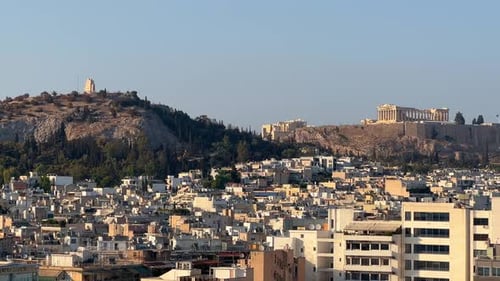 Lofos Philapappou et l'Acropole d'Athènes vus au loin, après-midi.