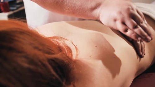 Woman Receives Relaxing Back Massage in Spa Setting