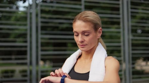 Woman Using Fitness Tracker Outdoors After Workout
