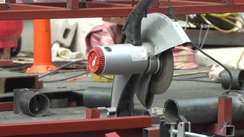 Close-up of cutting round steel tube with a cut-off wheel machine at the construction site