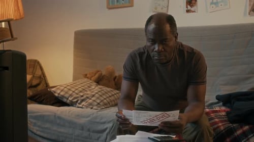 Portrait of Distressed Middle-Aged African American Man Holding Past Due Bills