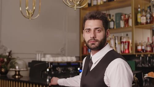 Confident Young Man Standing Behind a Bar